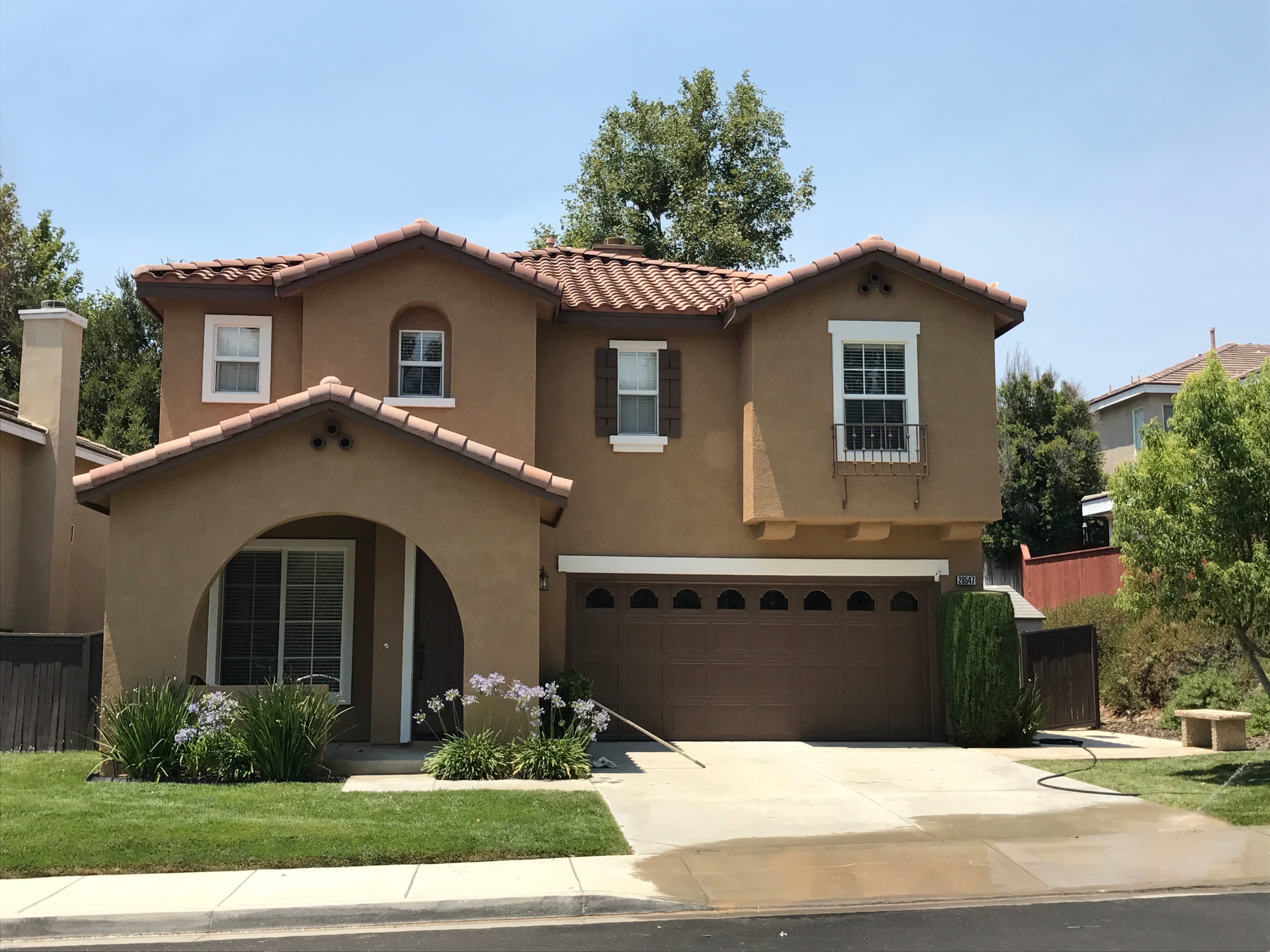 Before image by extreme painting for Spanish-style two-story repaint, single color with white accents.